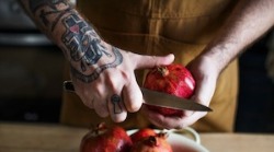 cook cutting a pomegranate