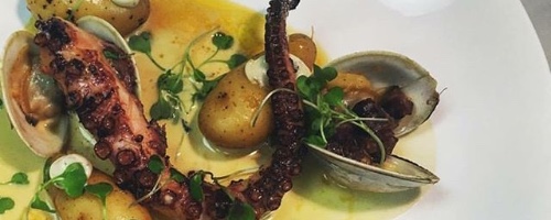 Charred octopus, roasted fingerlings, clams and bacon