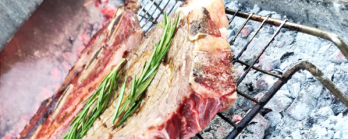Sliced local beef on a bed of fresh rocket, datterini, flake