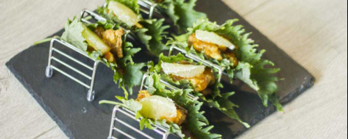 Taco de pollo satay sobre hoja de shiso